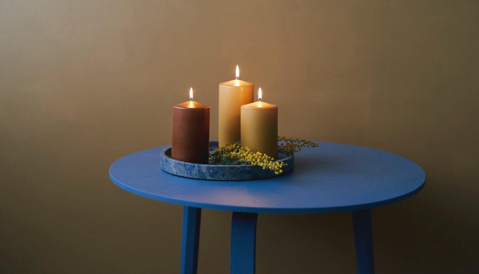 Havi Pillar Candles on a blue table. Made in Finland since 1829 