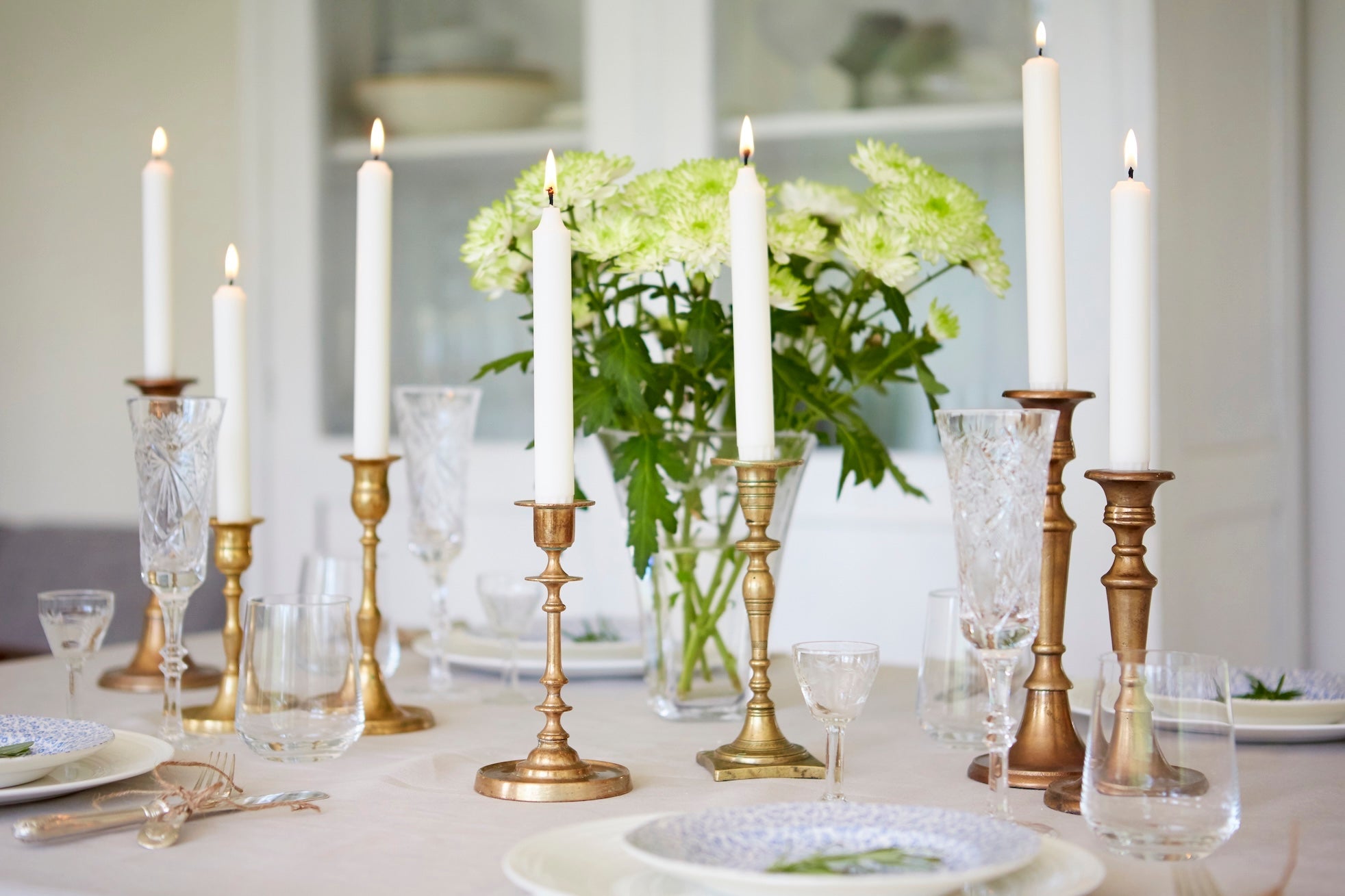 Havi Crown Candles shown in brass candleholders along the centre of a beautifully set dinner table