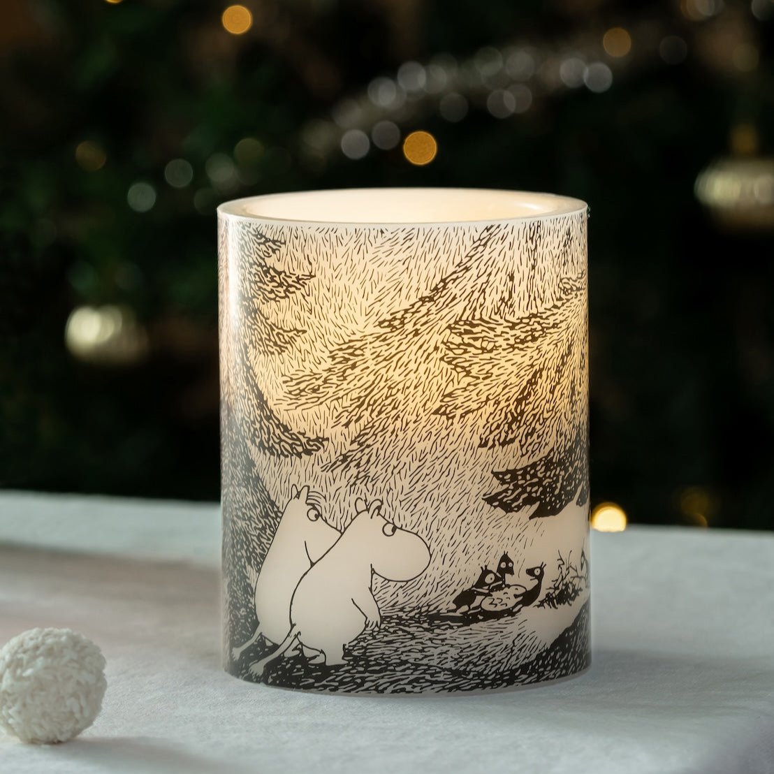 The Pond LED candle on a table with a Christmas Tree behind.  Designed by Muurla Design