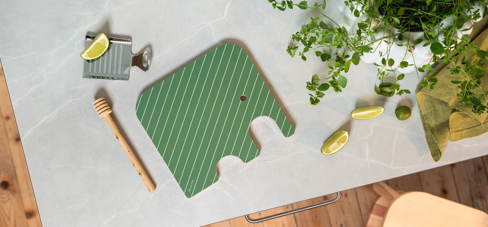 Muurla Elephant Chop and Serve Board,  shown on a kitchen worktop surface, with a lemon grater and honey dipper alongside 