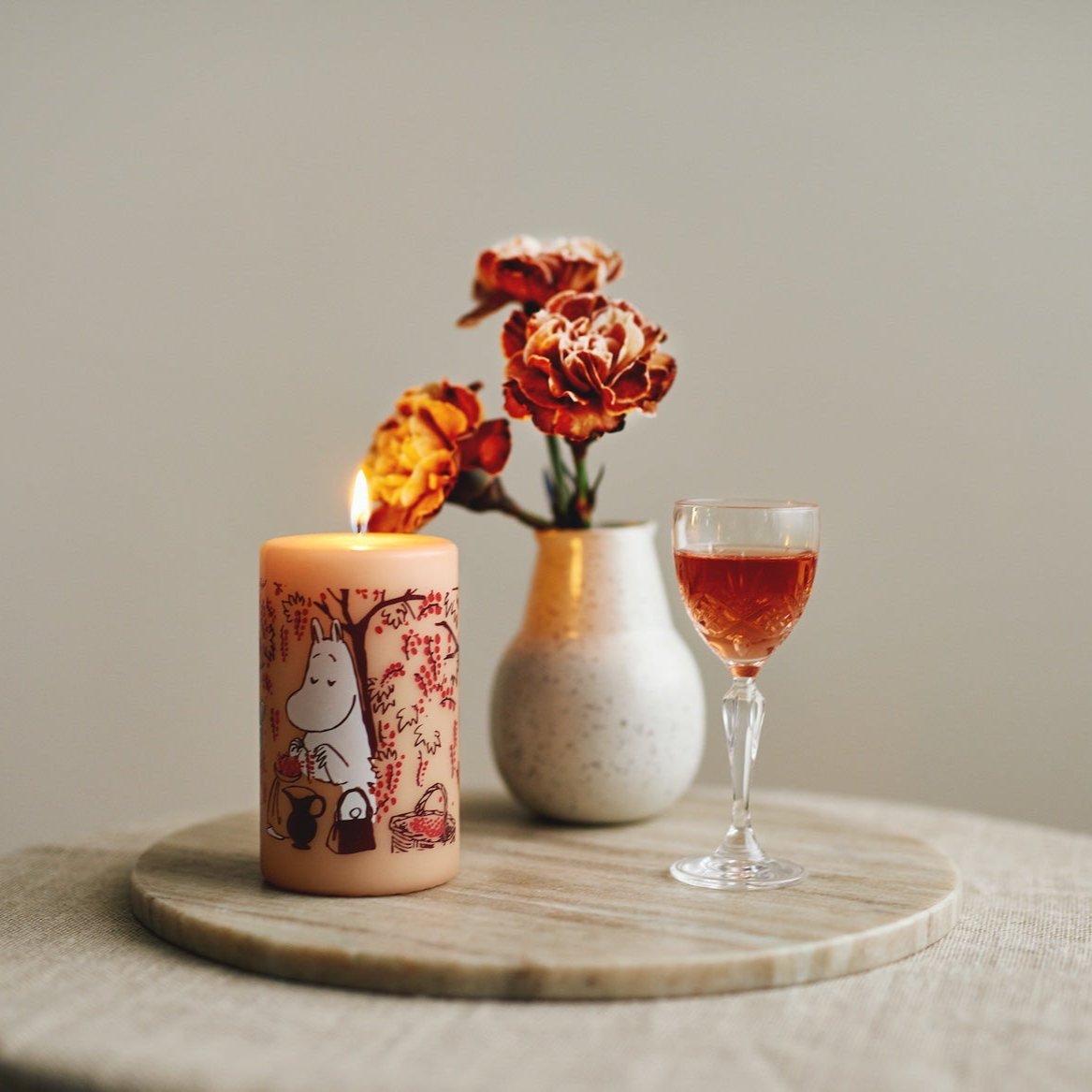 Havi Moomin Berries Pillar Candle.   Next to flower and a glass of sherry