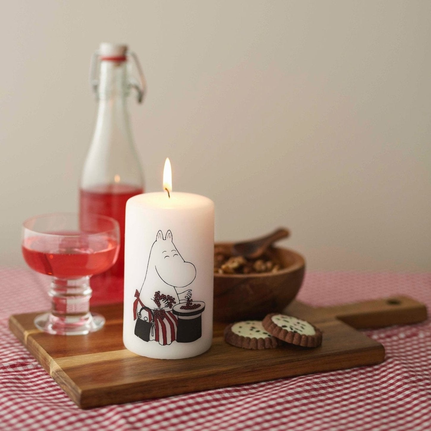 Havi Moomin White Moominmamma Pillar Candle on a chop and serve board with a drink and snacks