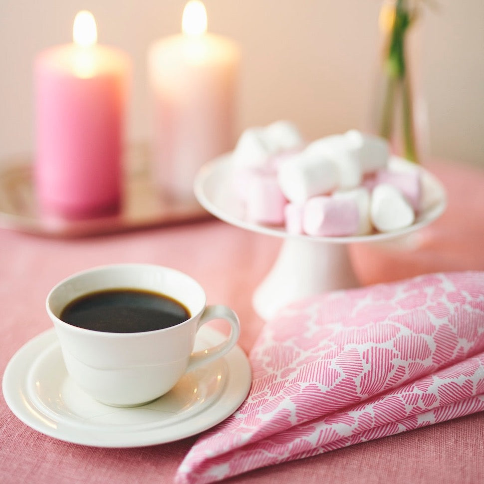 Pink Paper Napkins folded over next to a cup of coffee and a plate of marshmallows