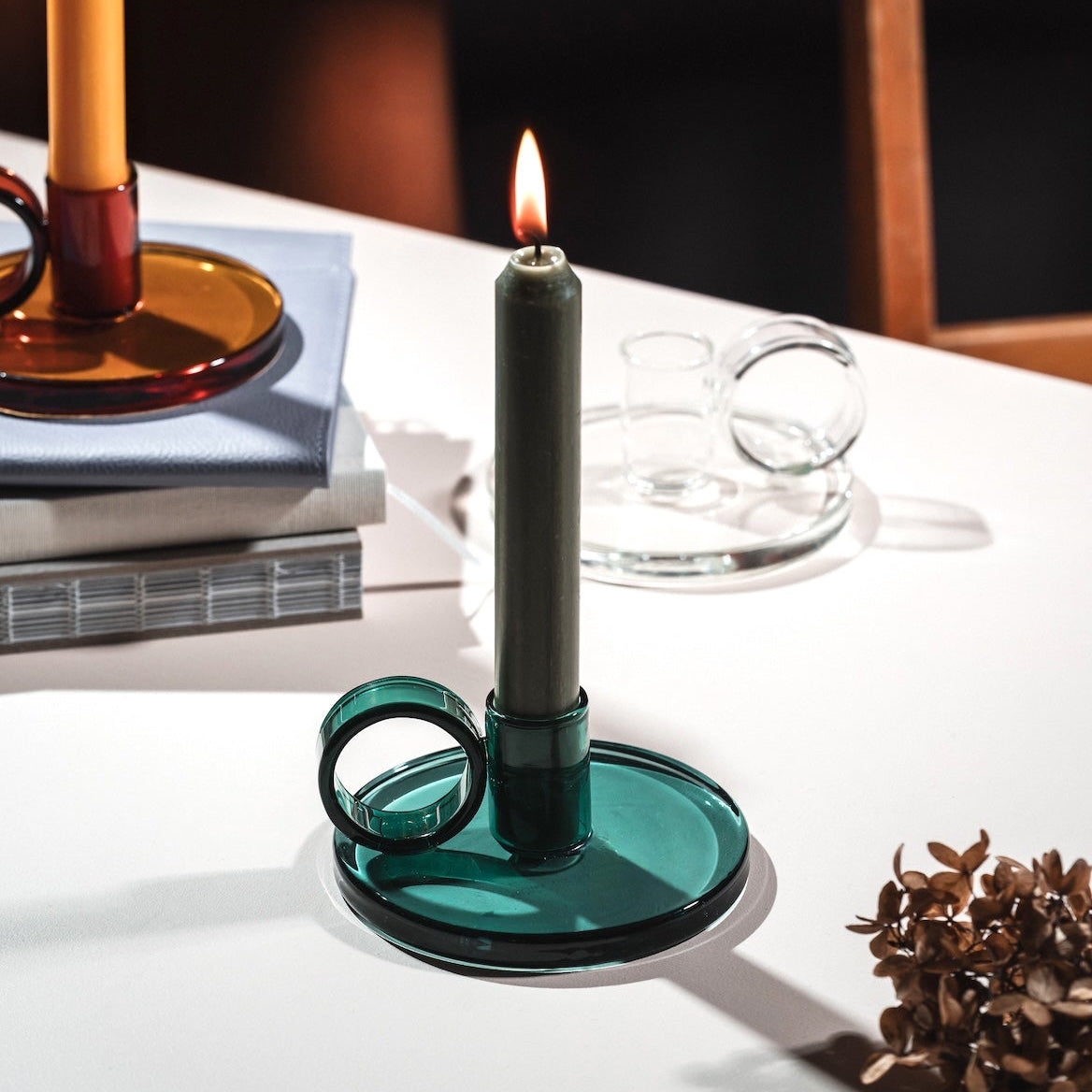 Loop Candle holder with a candle on a table with a blurred background