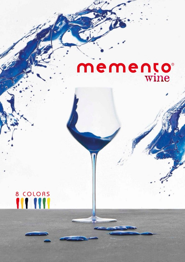 A wine glass with blue liquid inside, set against a white background with blue paint splashes and the red text 'memento wine'.