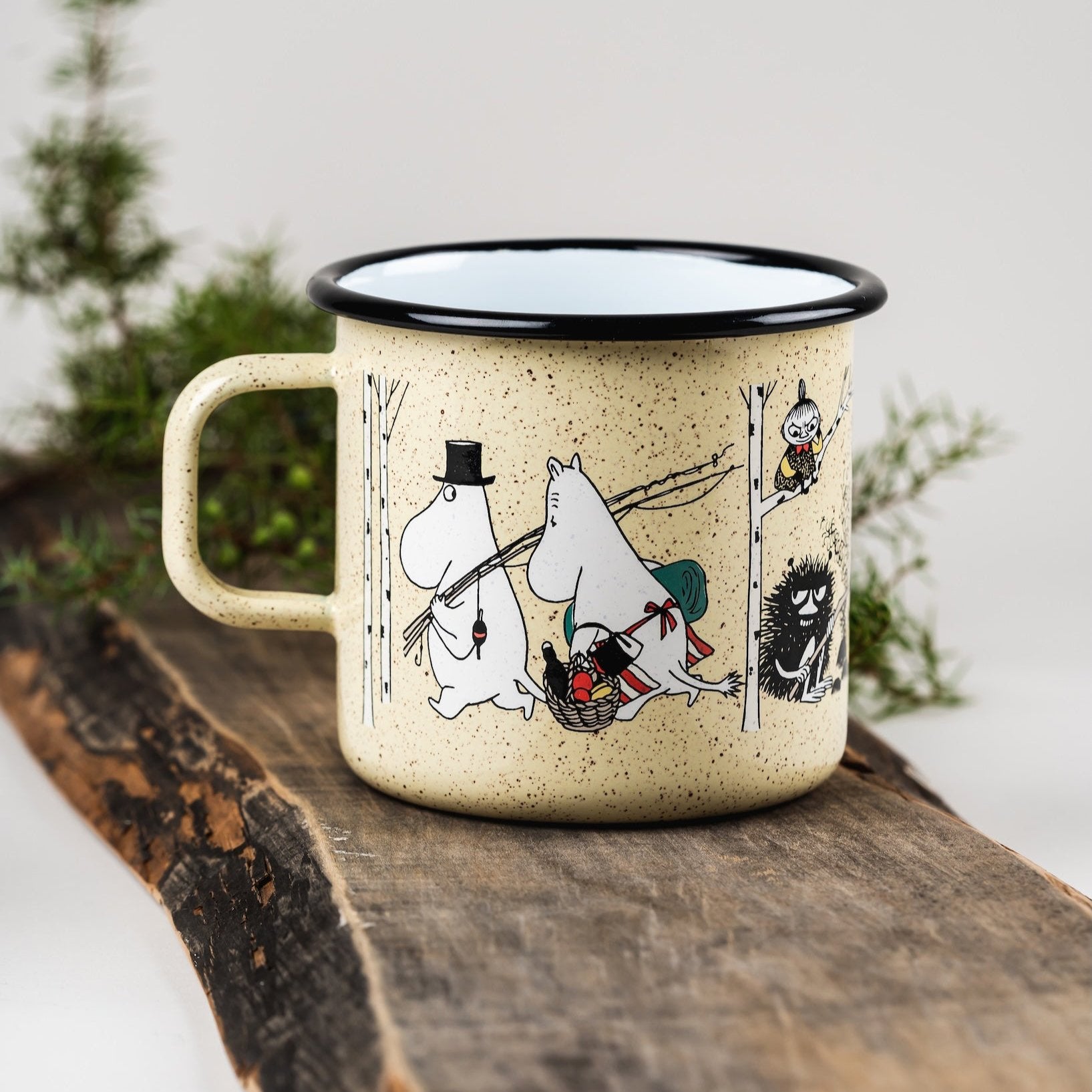 Moomin Campers Enamel Mug held in both hands by a lady outside, wearing a winter jumper 