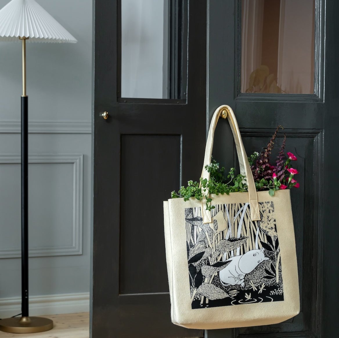 Moomin The Pond Tote Bag by Muurla Design.    Hanging on the door handle and full of flowers