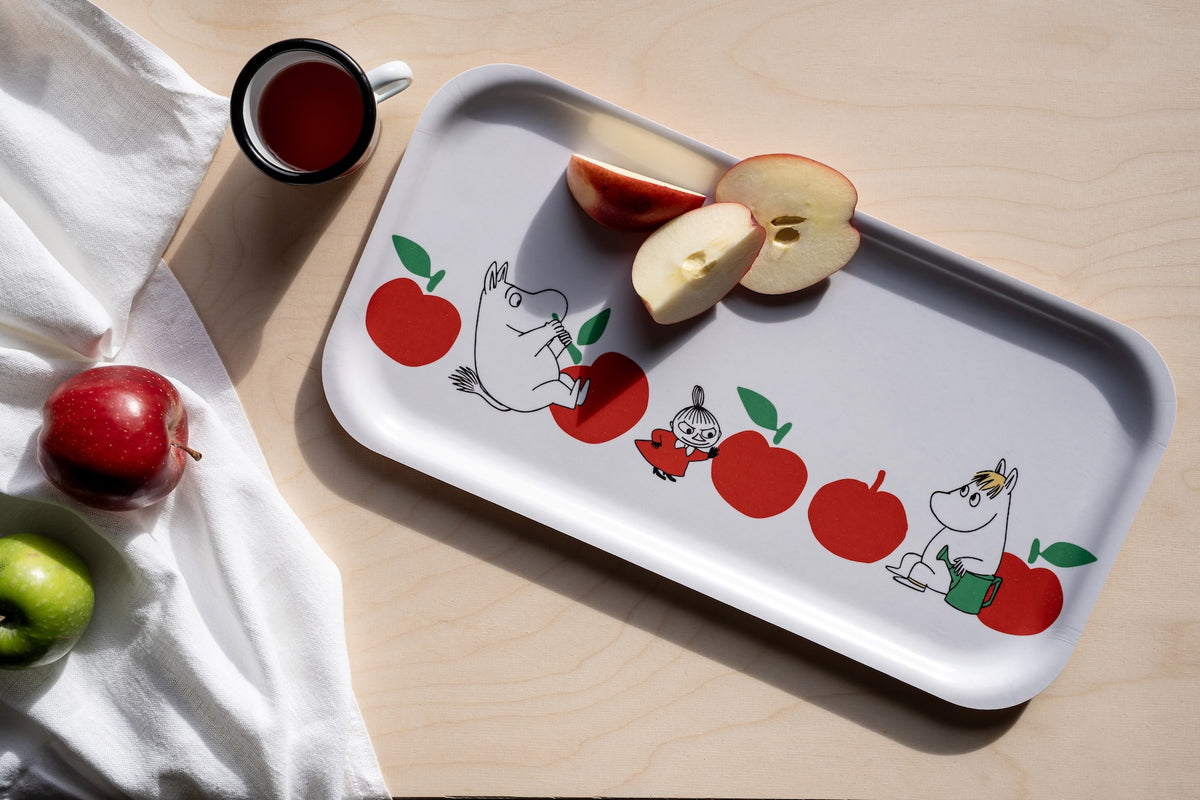 Tray with cartoon characters and apples on a wooden surface