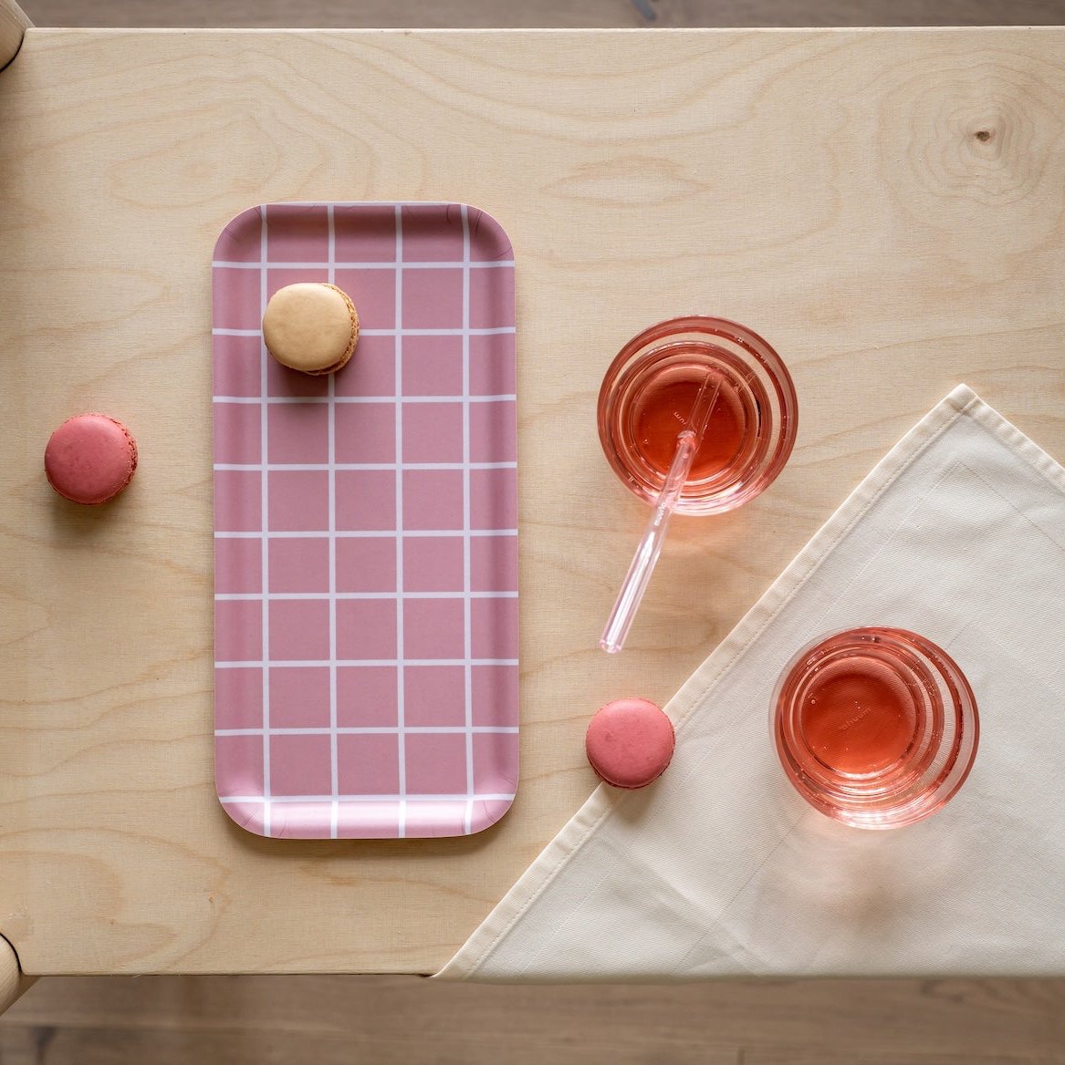 Muurla Checks and Stripes Tray. Pink. 27 x 13cm.  Pictured on a birch table next to glasses of juice.