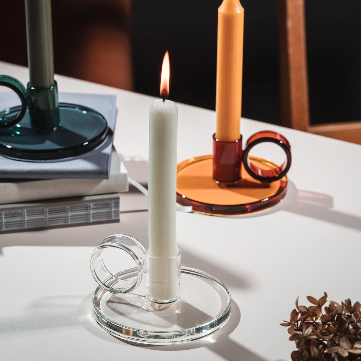 Loop Chamberstick candle holders on a table with books and a tablecloth.  