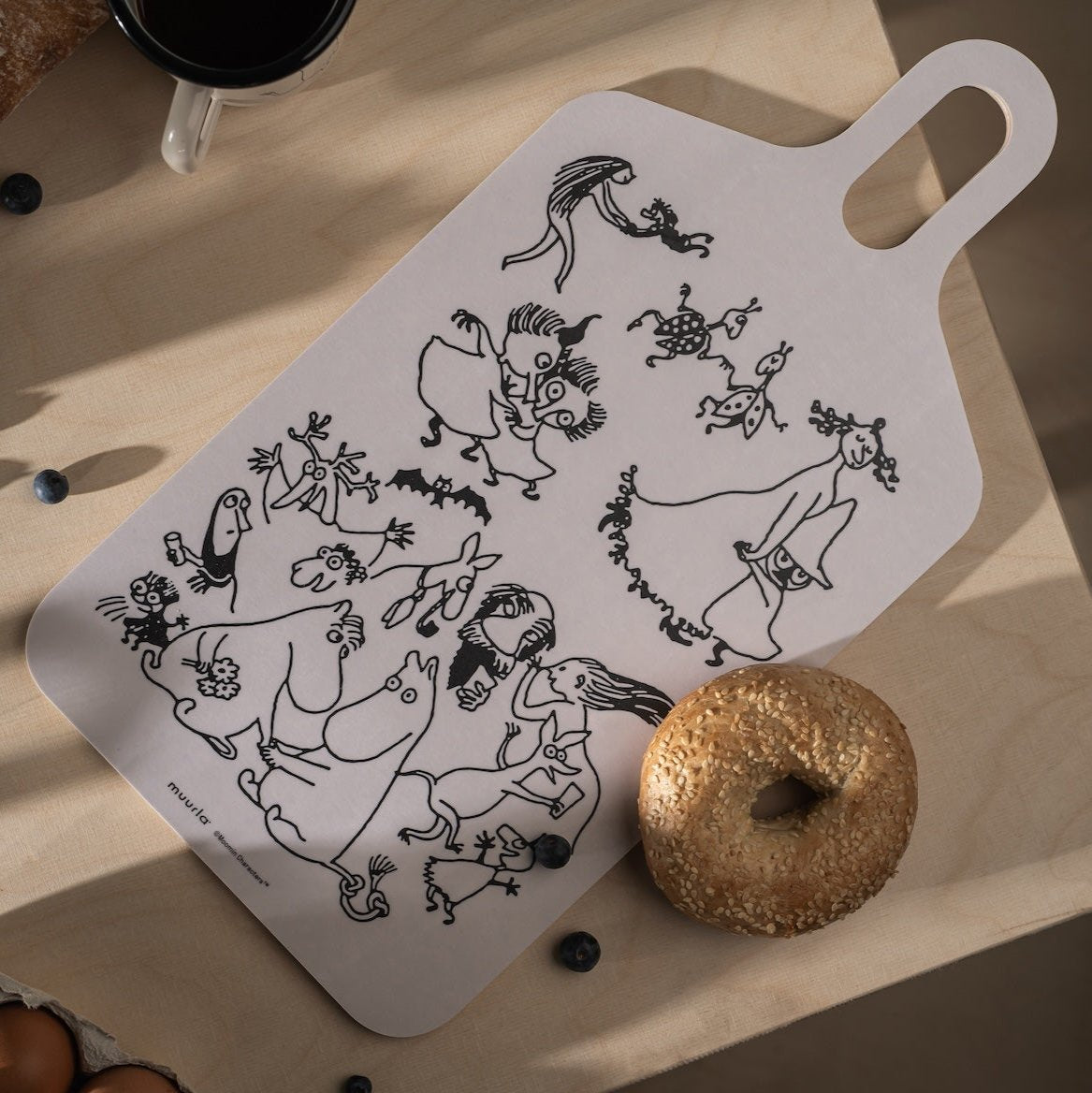 Moomin 80 Chop and Serve Board by Muurla Design.  Shown with a breakfast bagel and berries dotted alongside.