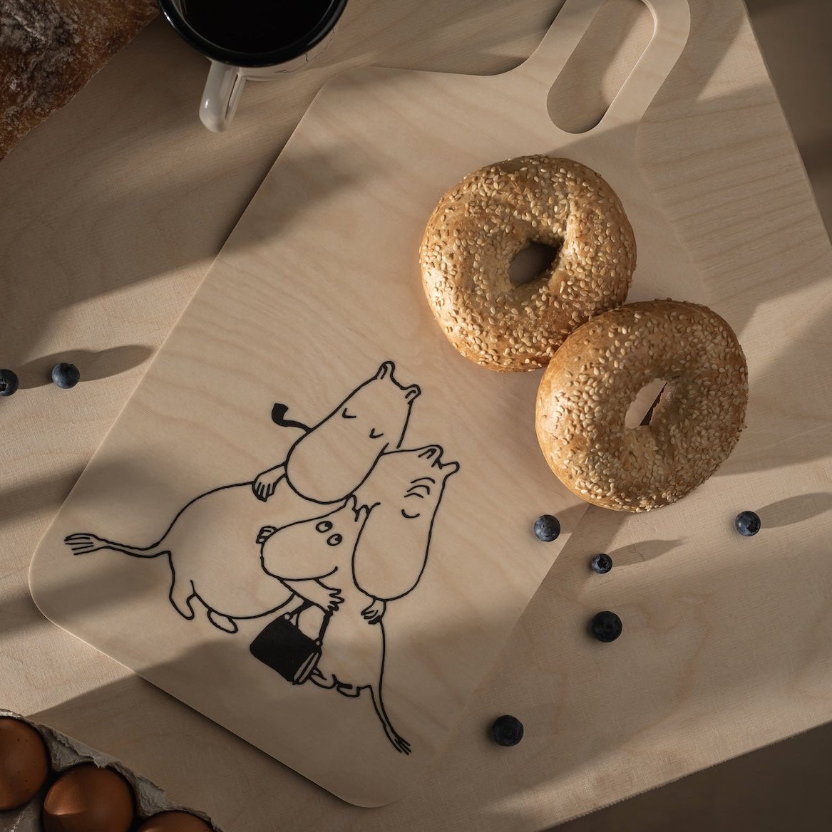 Moomin 80 Chop and Serve Board by Muurla Design.  Shown with a breakfast bagel and berries dotted alongside.