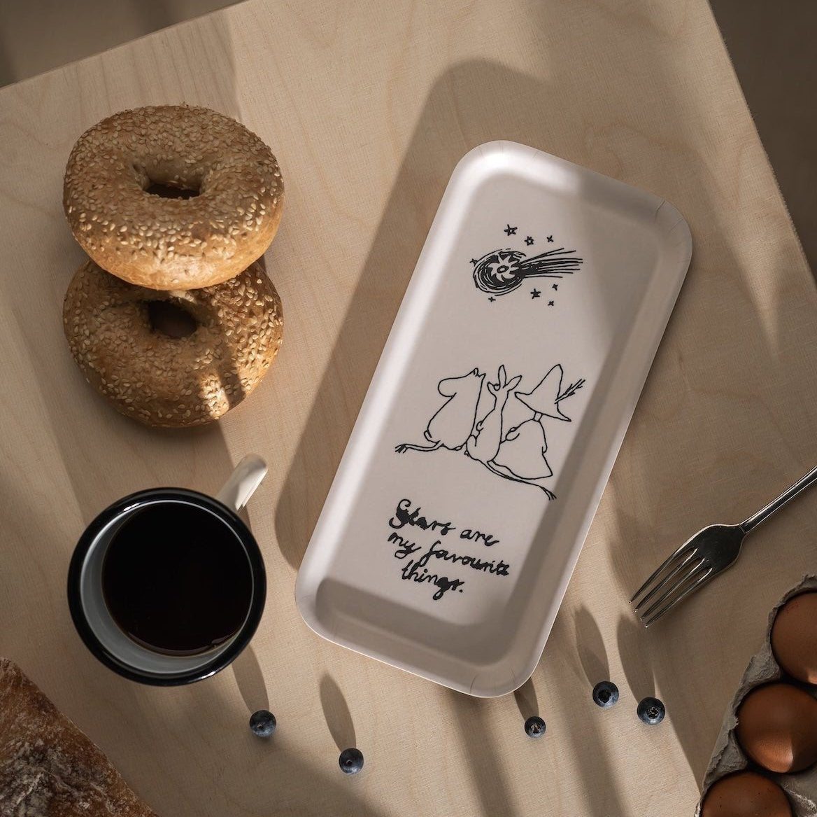 Moomin 80 Tray by Muurla Design next to breakfast bagels and coffee