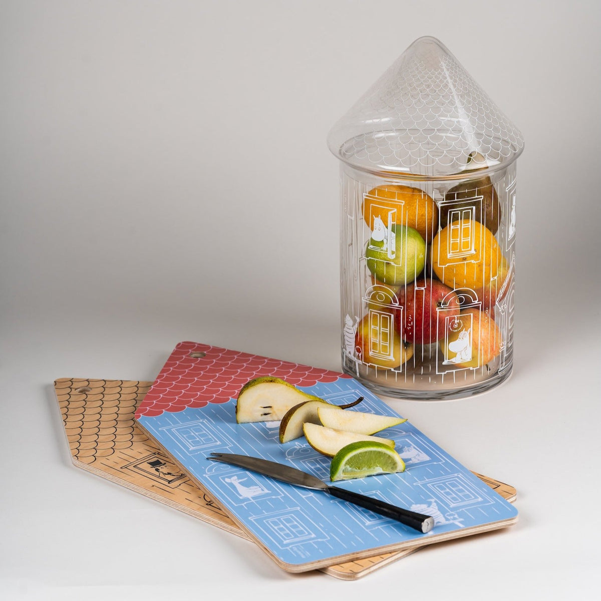 Moominhouse Glass Jar, next to a Moominhouse  Chop &amp; Serve board with chopped apple and a knife resting on top