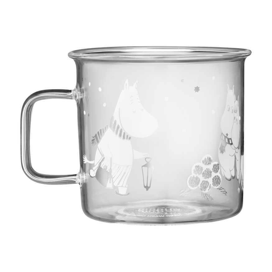 Moomin Let It Snow Glass Mug by Muurla, shown on a white tablecloth next to gifts and candles