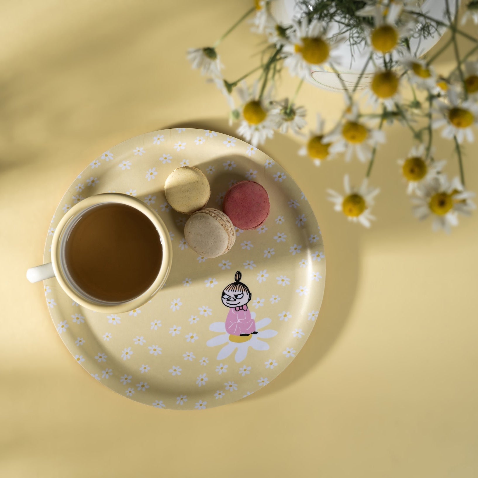 Moomin Flowers Tray featuring Little My on a bed of white flowers.  Tray has an enamel mug and macaroon biscuits on it.