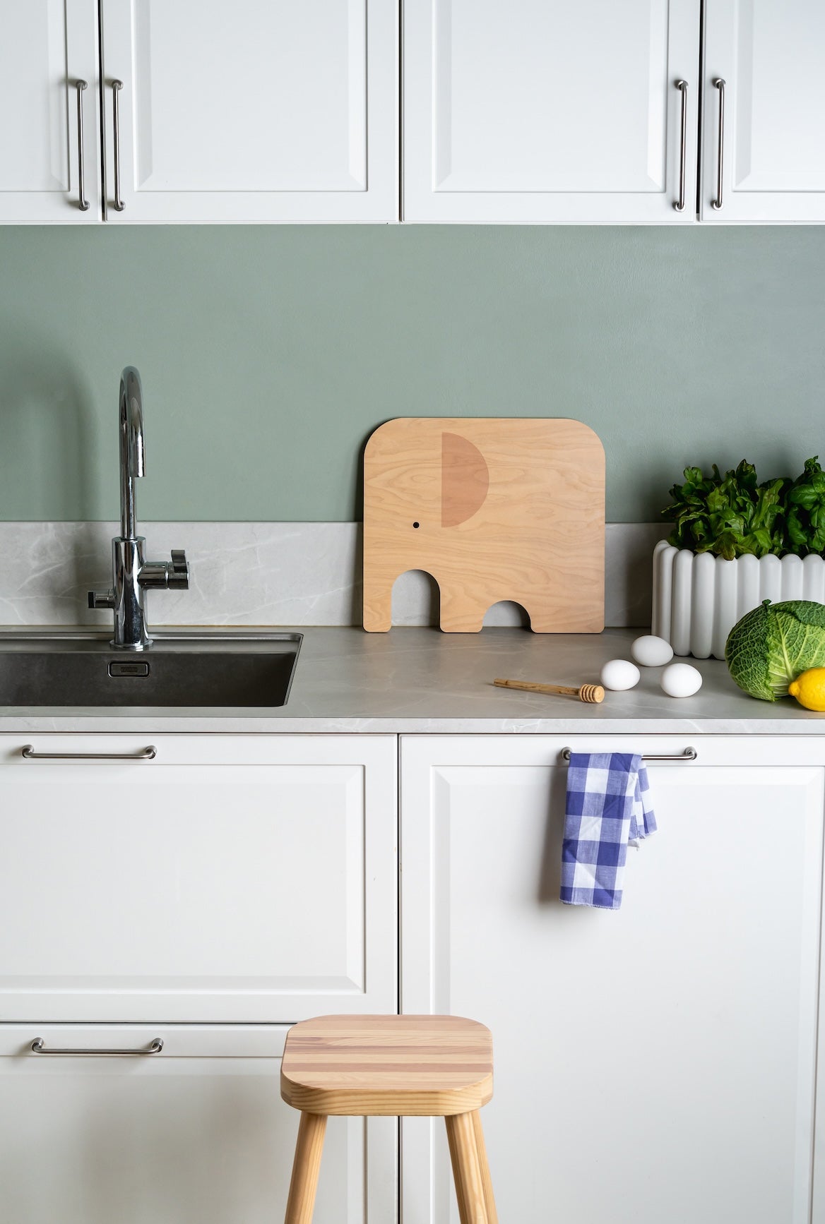 Kitchen setting with a Muurla Elephant Chop and Serve Board on the kitchen side, near the sink