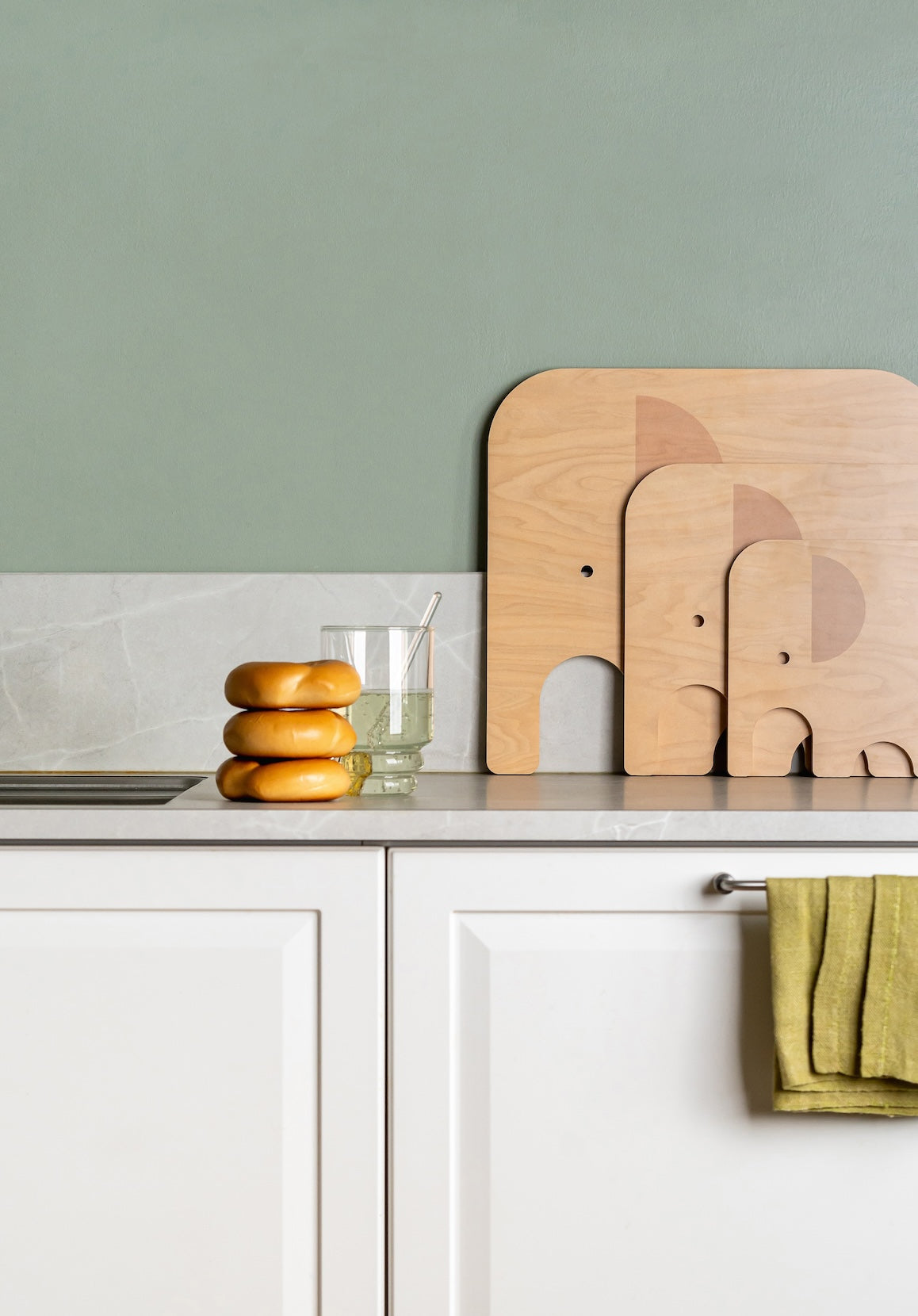 3 sizes of Muurla Design&#39;s Elephant Chop and Serve Boards series.   Sitting together, showing their birch side, near the sink in a Kitchen setting