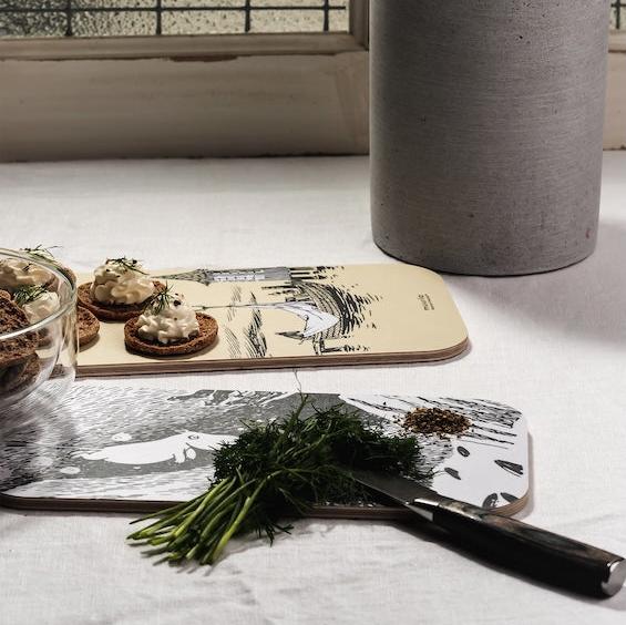 Adventures on the water chop and serve two sided board, being used in the kitchen to prepare herbs and snacks 