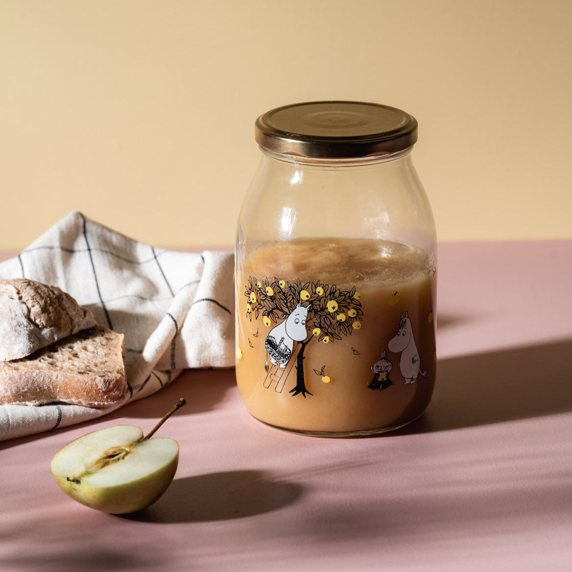 Moomin Glass Jar, Apples, 1 L shown full of Apple compote and next to an apple and slices of bread