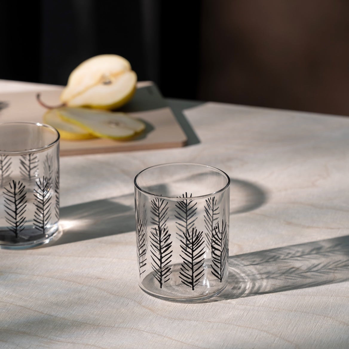 Two glass tumblers with Spruce patterns on a marble surface. Made by Muurla Design Teemu Jarvi