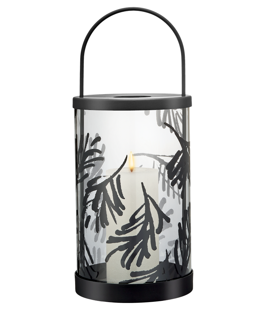 Decorative Teeum Jarvi  lantern with a candle on a wooden surface against a green wall