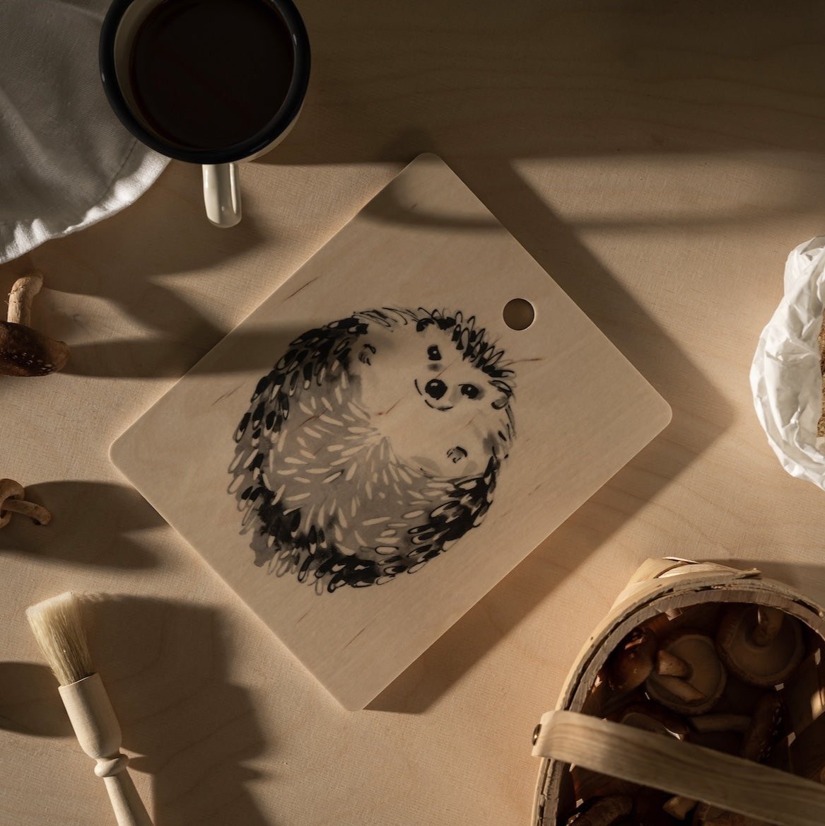 Teemu Jarvi Hedgehog Chop and Serve board in Birch.   Shown on a table alongside cooking ingredients: mushrooms, sugar, etc