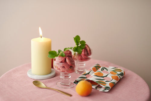 Havi Candles and Nectarine Paper Napkins.  On a table with glass dishes