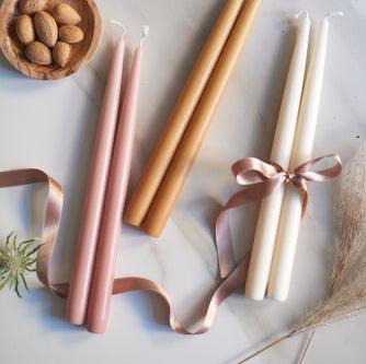 Havi Candles lying flat on a table and tied with ribbons.   Havi candles are made in Finland.  100% stearin