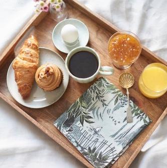 Breakfast tray with coffee, croissant and juice, and Havi Paper Napkins with a Moomin design