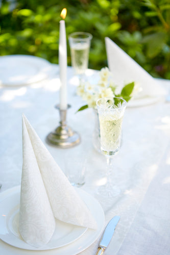 Havi Victoria Linen Paper Napkins displayed on a wedding table setting with cut glassware and silver candlesticks and cutlery