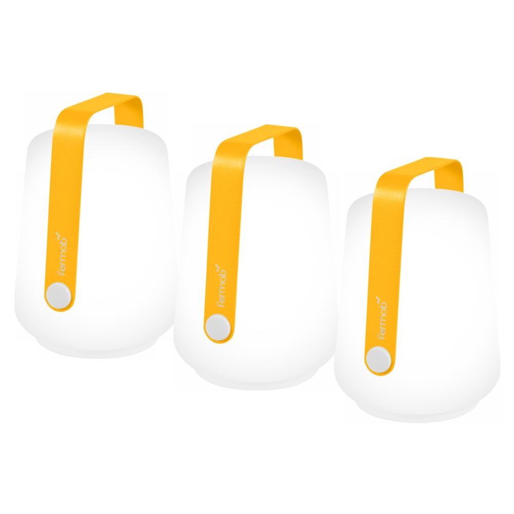 3 Fermob lanterns in Honey on a White background. The lanterns have the Fermob logo on their metal handles.