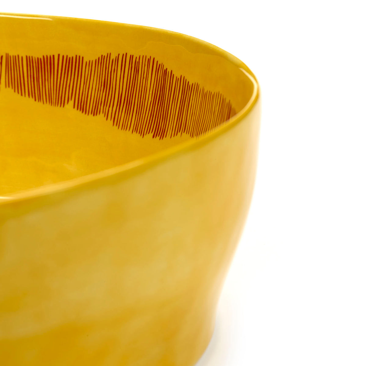 Ottolenghi for Serax Feast collection, close-up side view of salad bowl, with sunny yellow swirl-stripes red design.