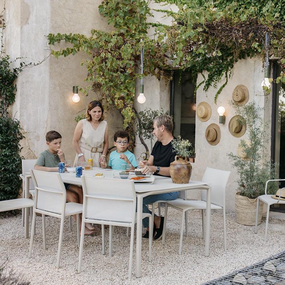 Family dining outside with Fermob Aplo Lamps hanging from suspensions straps behind them